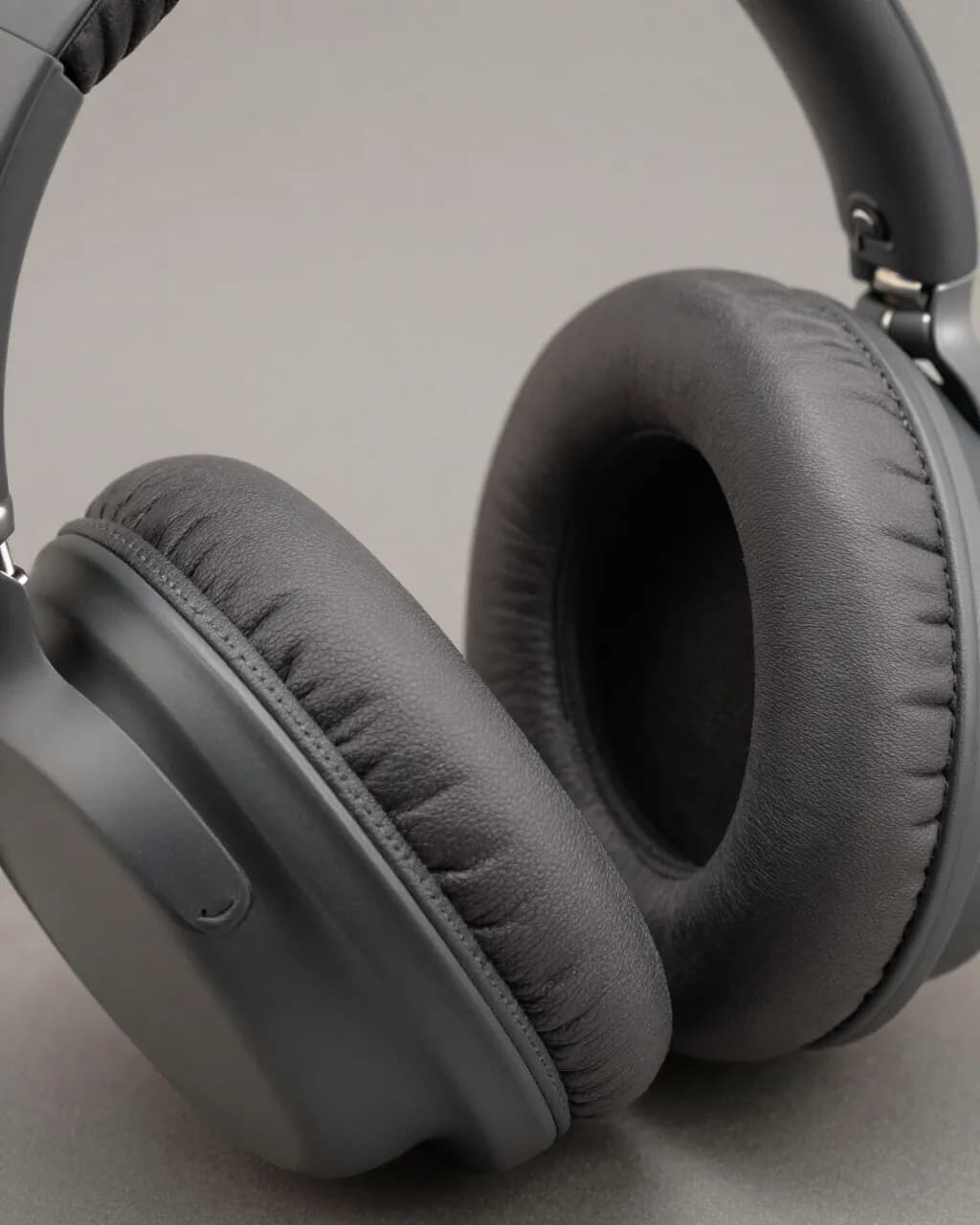 Close view of the stitched memory-foam cushions on two Oswin One earcups