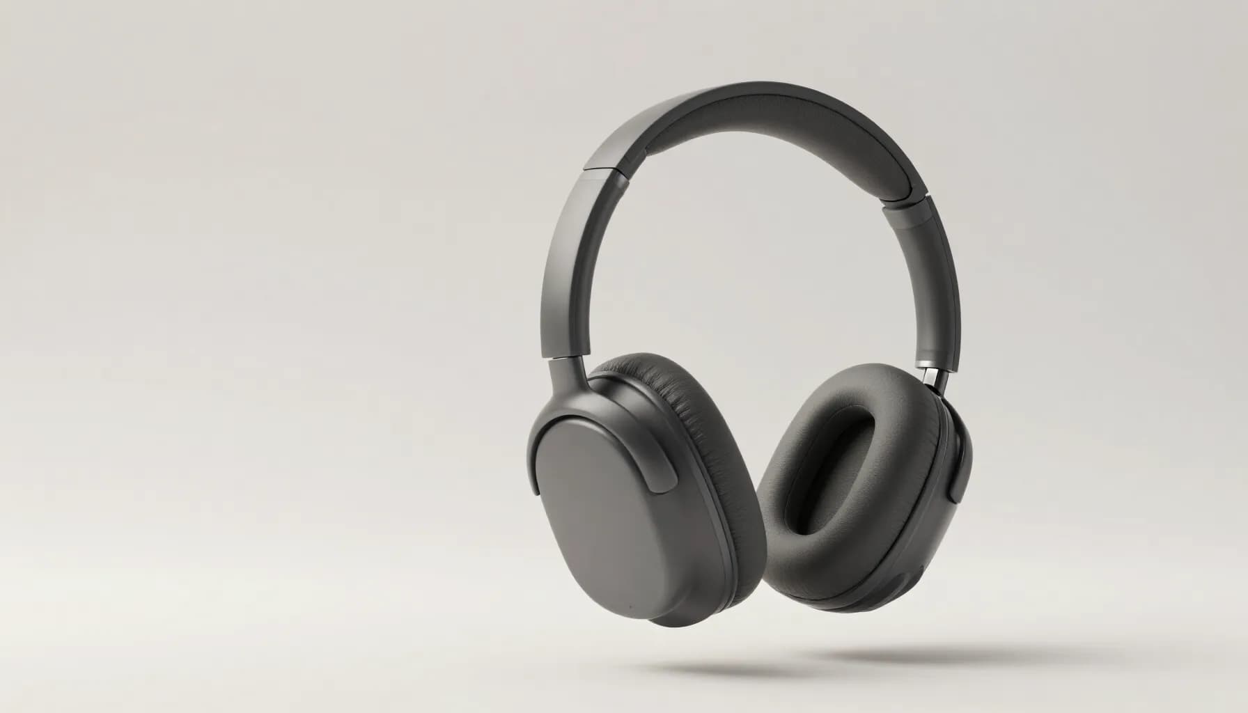 Oswin One headphones in graphite, floating against a pale studio backdrop