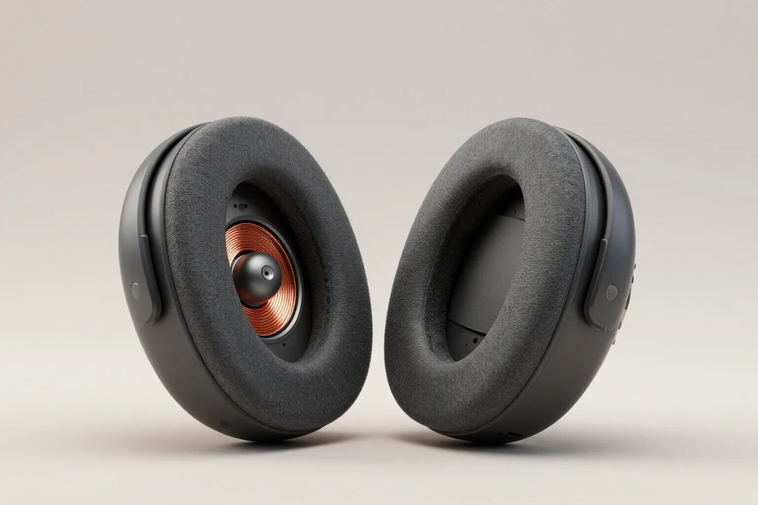Two Oswin One earcups, one showing the driver and copper voice coil behind the foam cushion