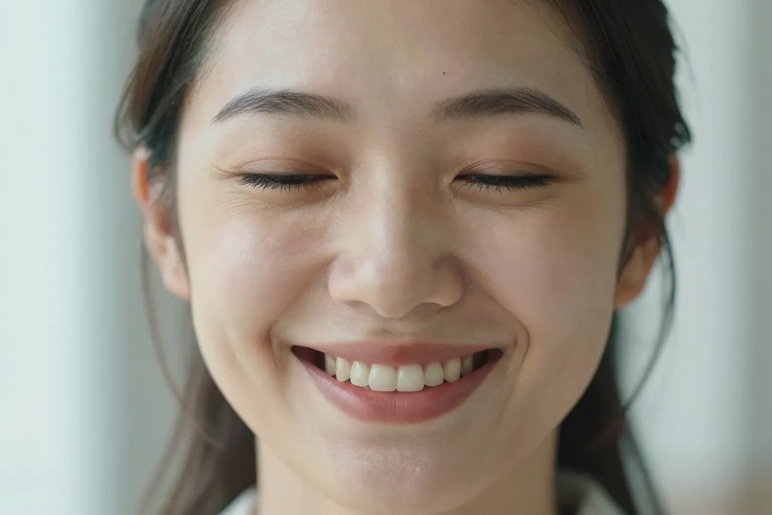 Close-up of a relaxed woman smiling with her eyes closed